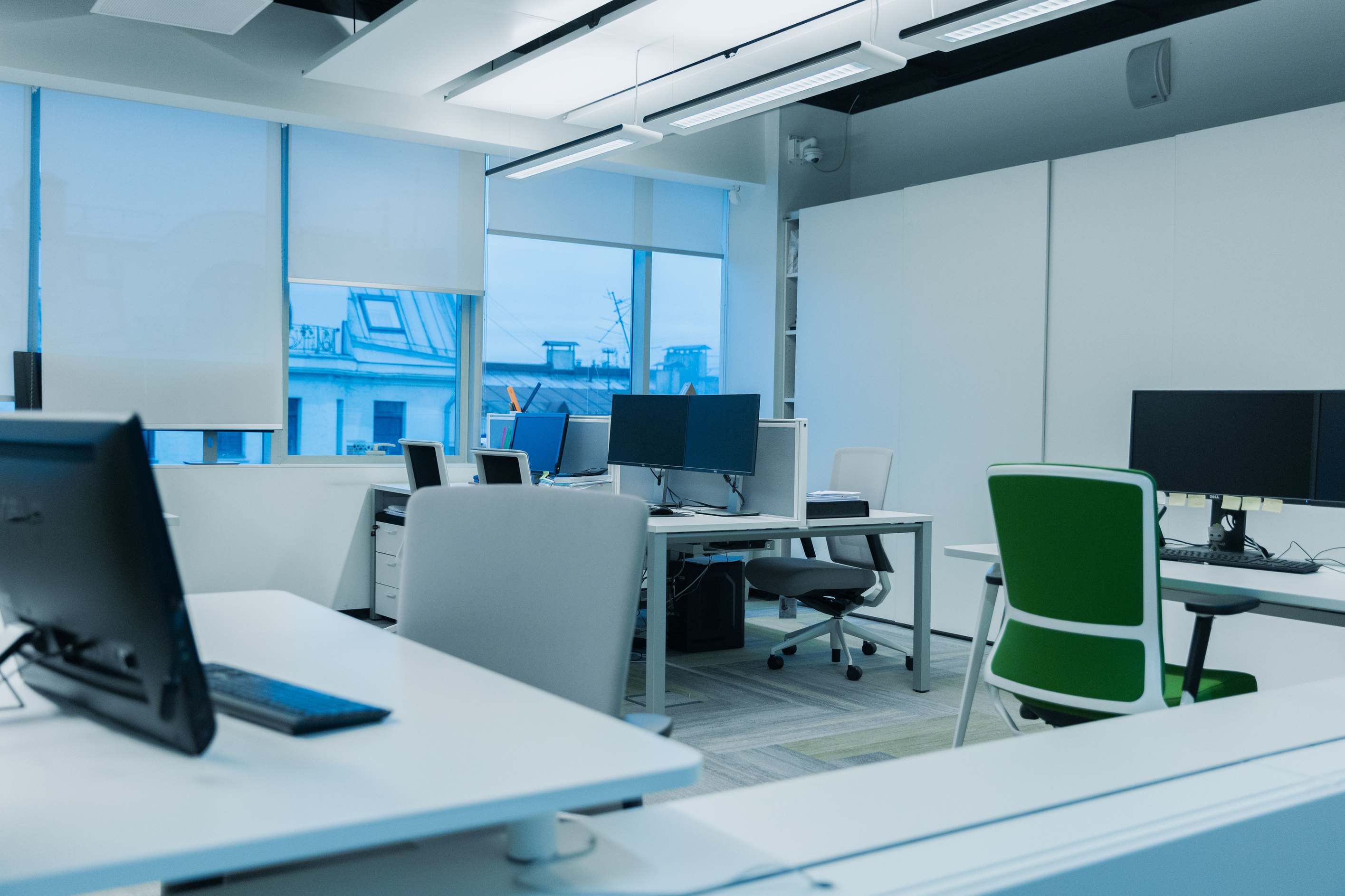 Office computer workstations in a bright modern workplace with large windows