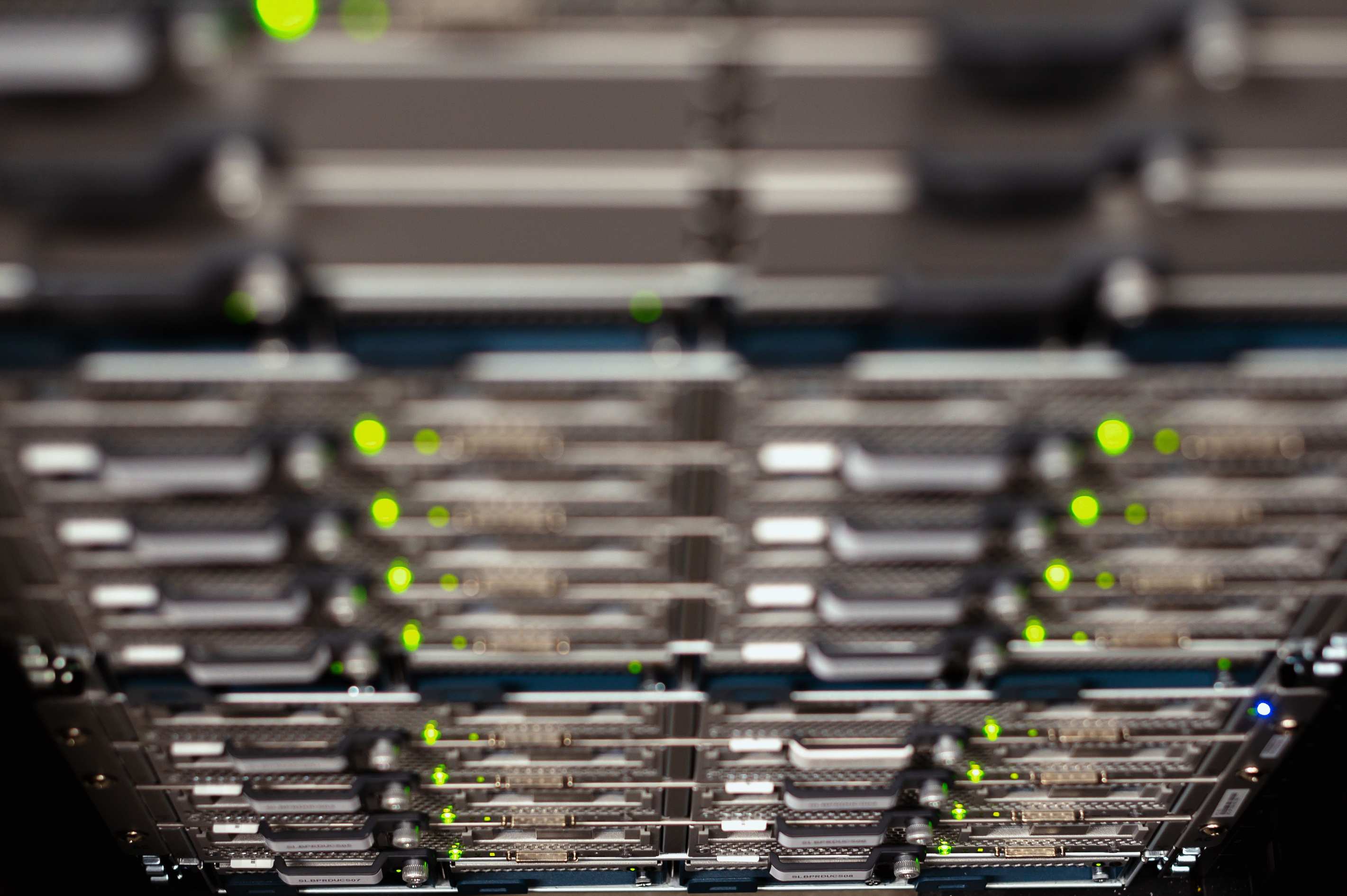 Wide view of a data hall with server racks and overhead cable trays in a modern data center